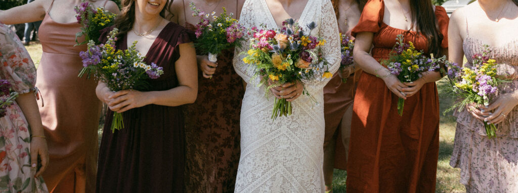 Bride and bridesmaids holding bouquets from a summer camp wedding in Wisconsin