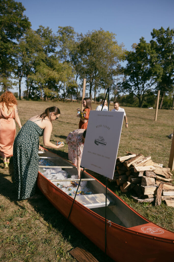 Wedding guests grabbing beer out of a beer canoe 