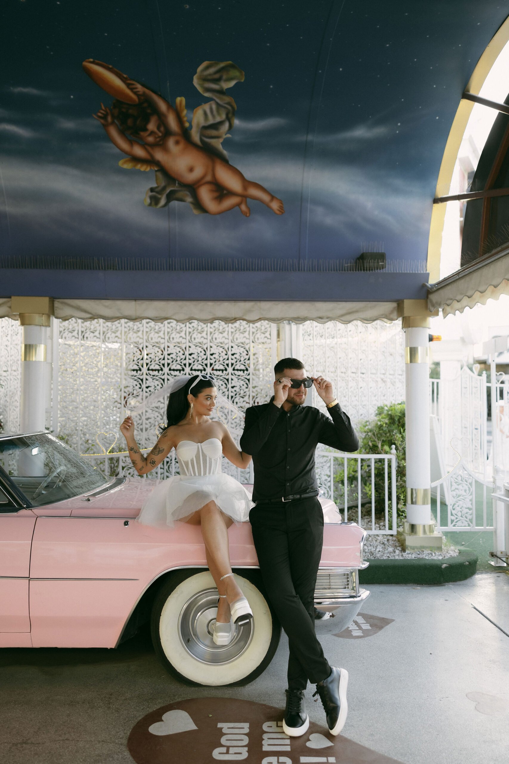 Bride and grooms portraits with the Pink Cadillac at Little White Wedding Chapel in Las Vegas