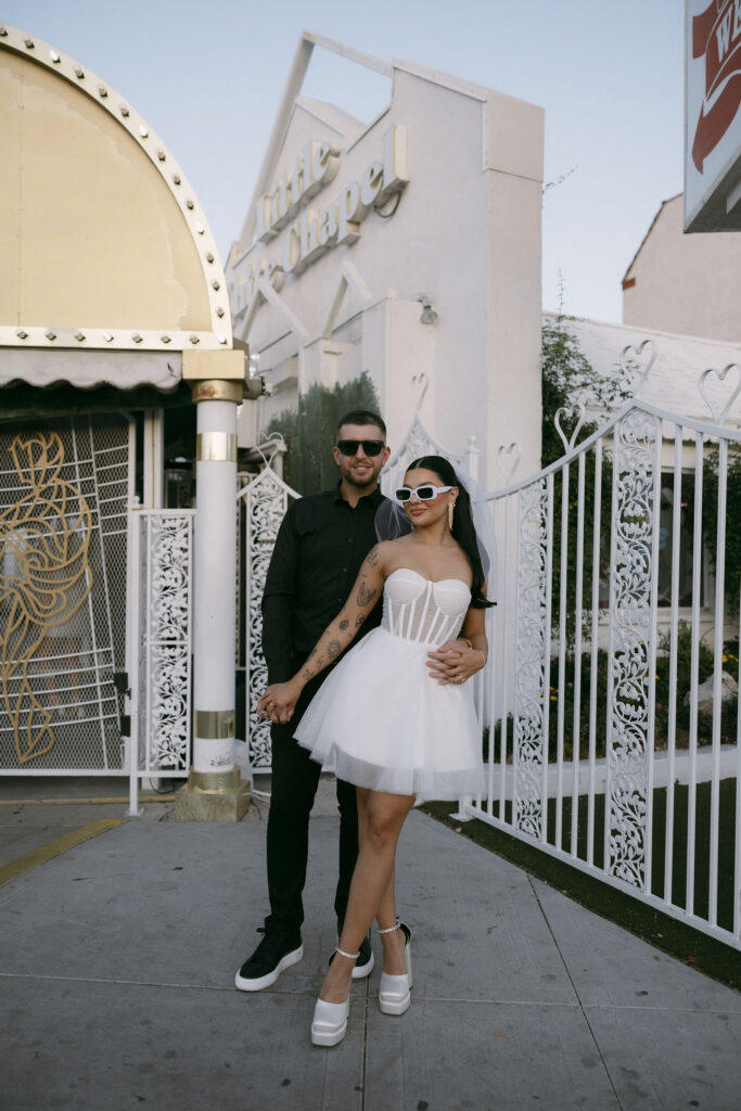 Bride and groom posing for portraits in Las Vegas while wearing sunglasses