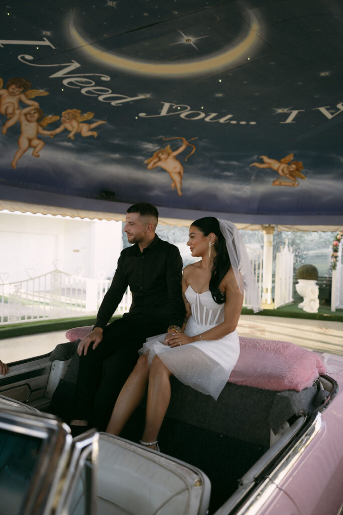 Bride and groom sitting in the Pink Cadillac at Little White Wedding Chapel in Las Vegas