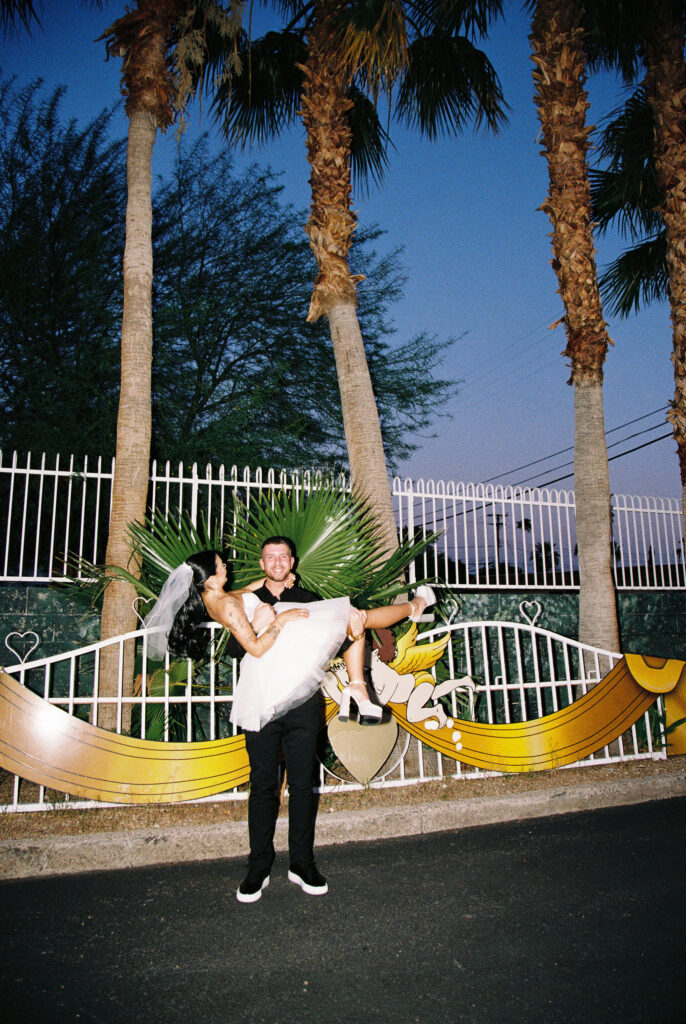 Film photo of a groom carrying his bride