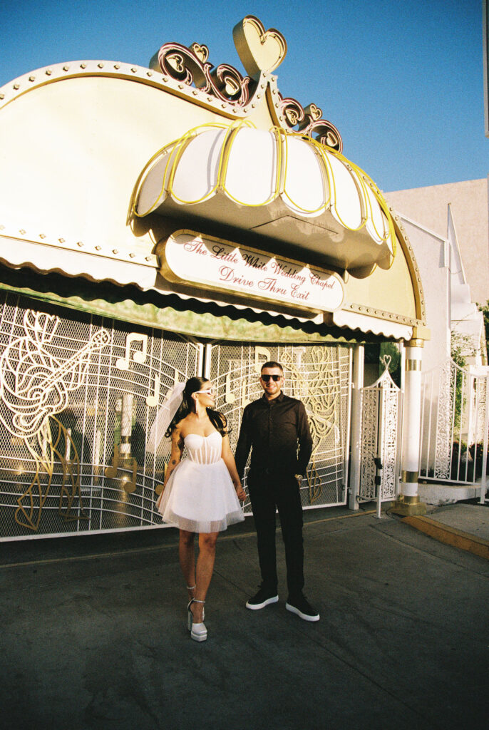 Bride and groom wearing sunglasses for their film elopement photos at The Little White Wedding Chapel in Las Vegas