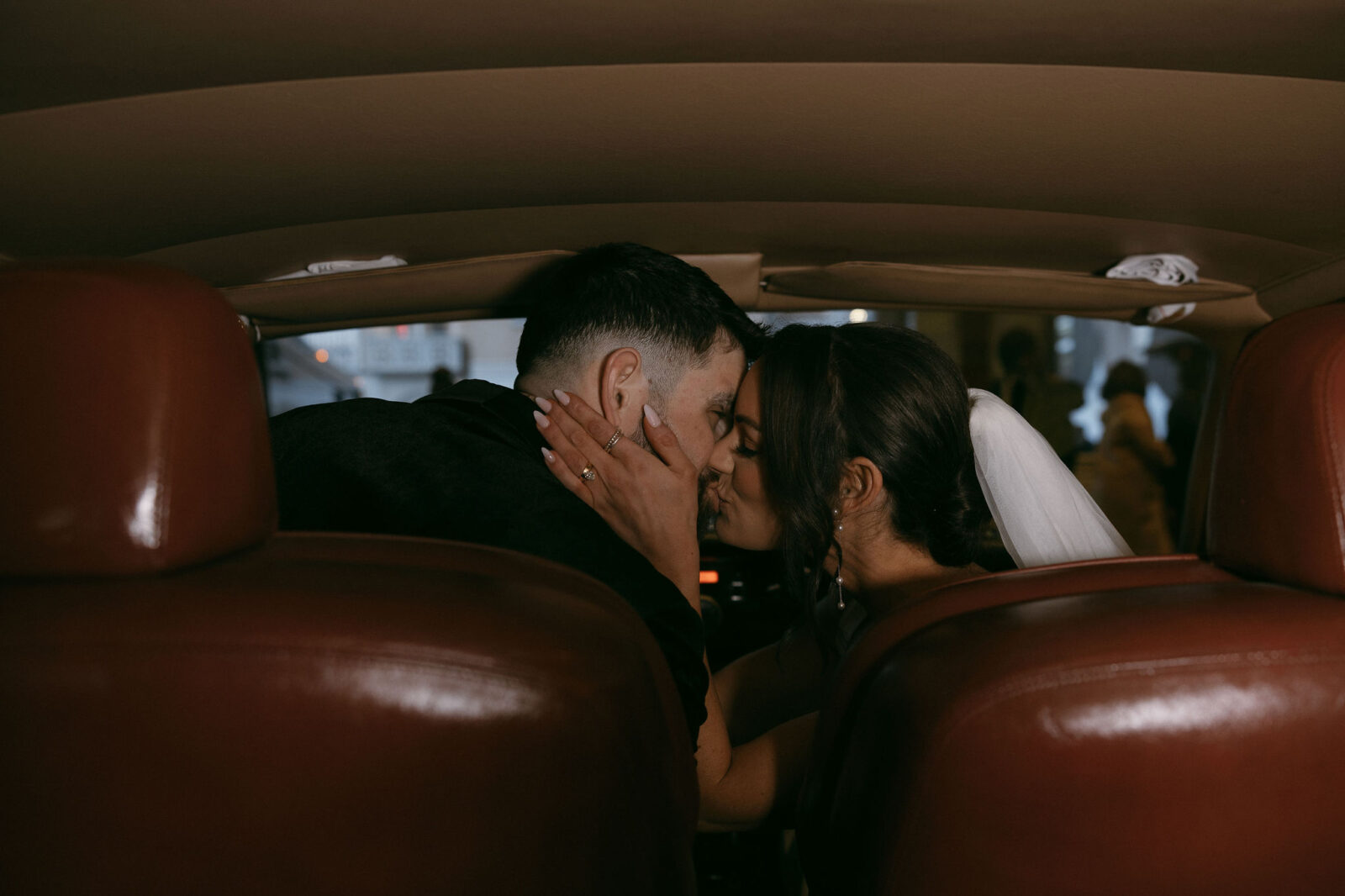 Bride and groom kissing in their Rolls-Royce