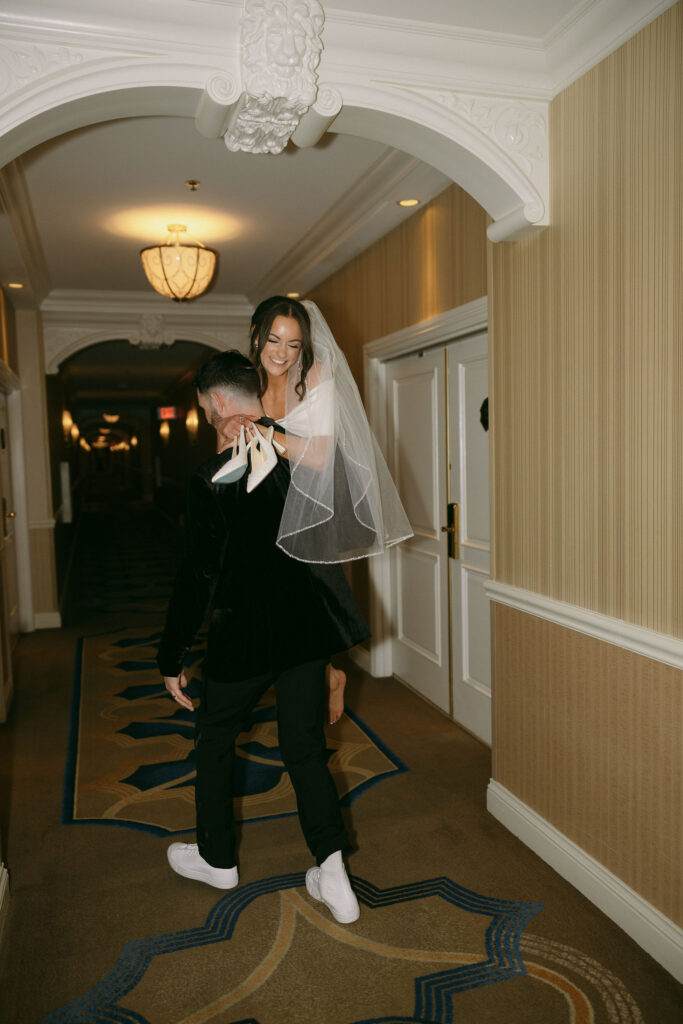 Groom carrying his bride down the hallway