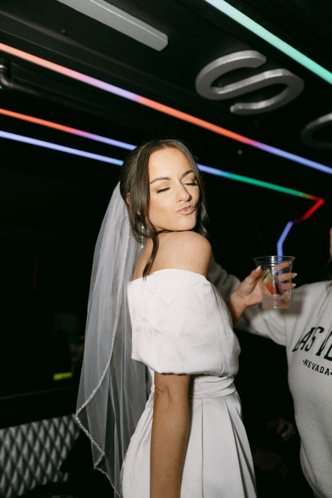 Bride posing for a flash photo on her party bus