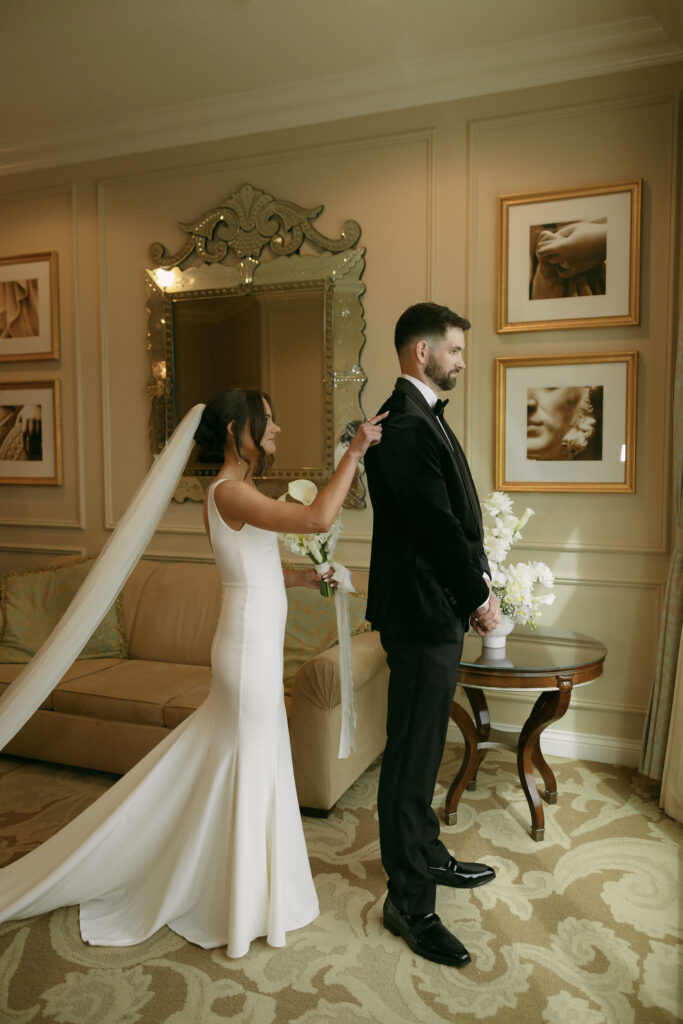 Bride tapping her groom on the shoulder before their first look