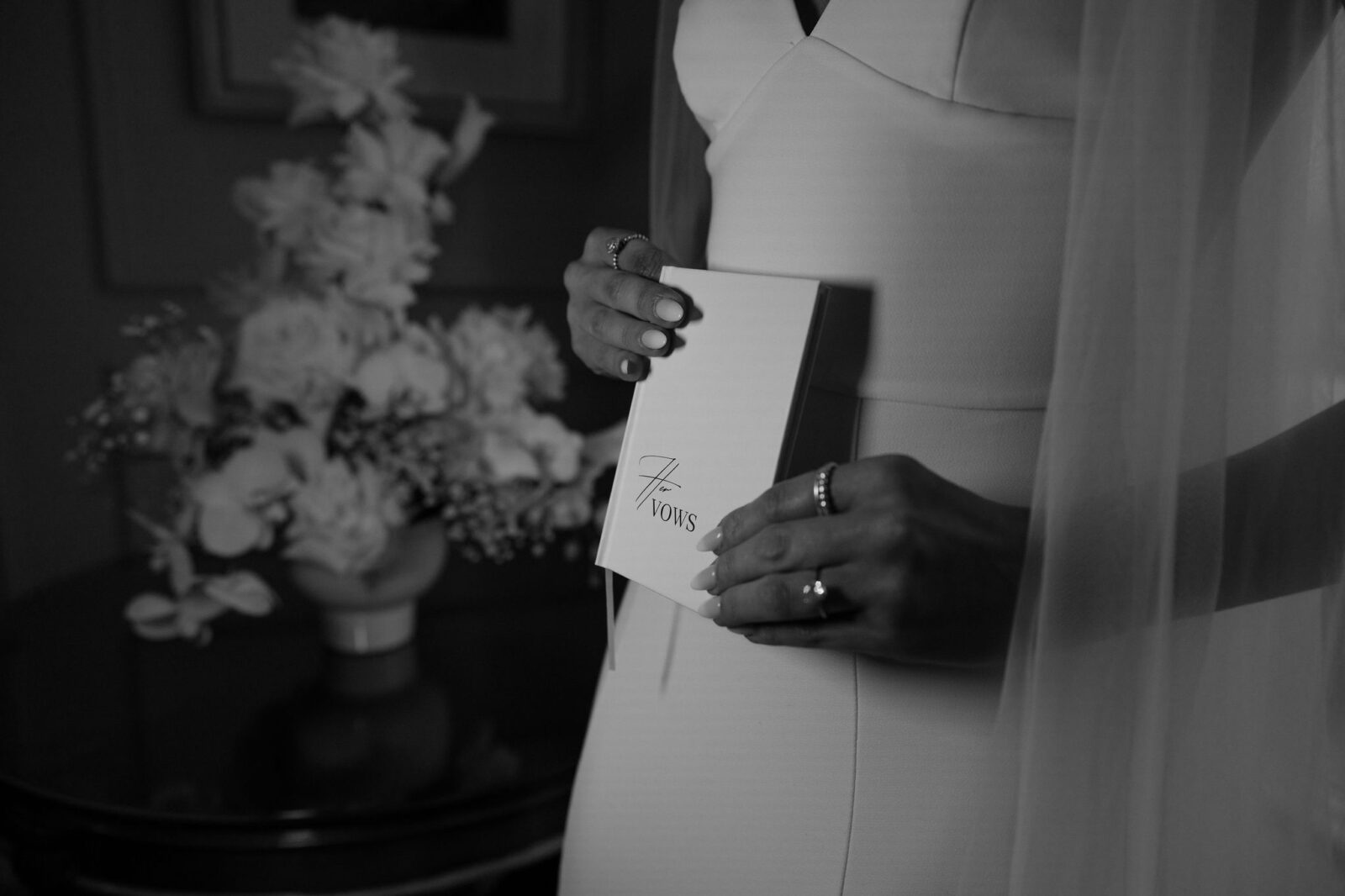 Black and white photo of a bride holding her vow book