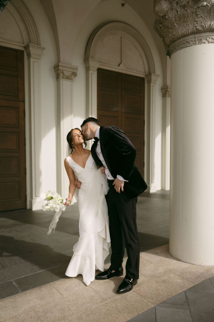 Groom kissing his bride on the cheek