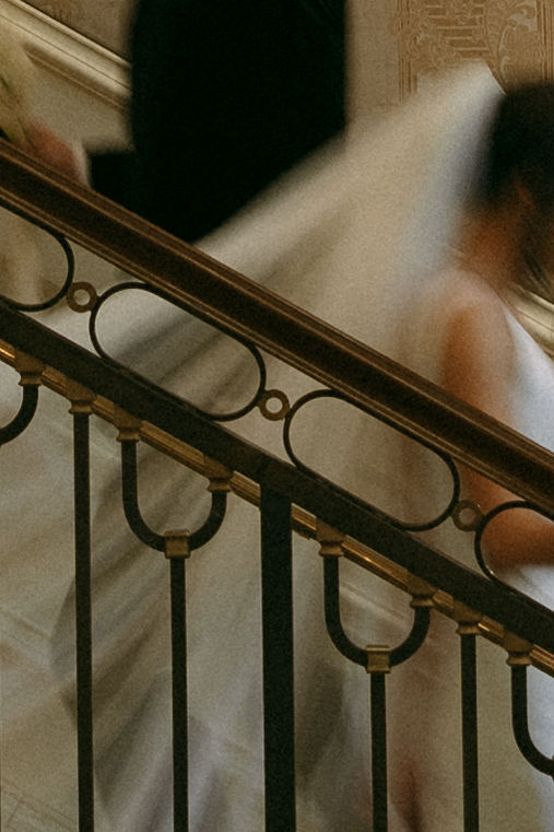 Bride and groom walking up and down a stiarcase