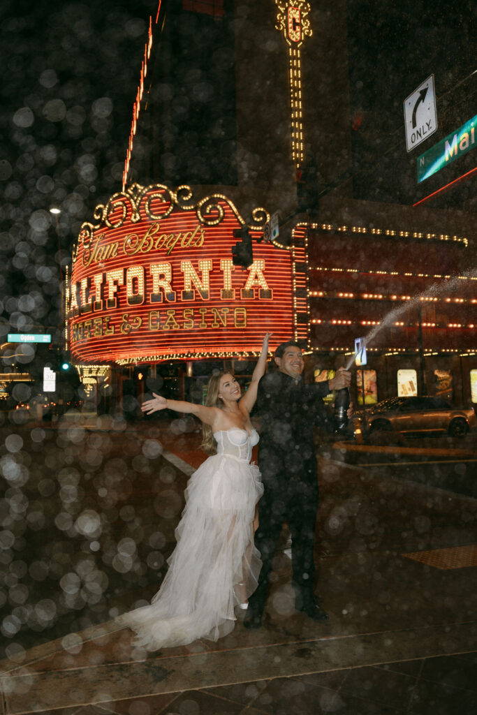 Bride and groom popping champagne in downtown Las Vegas