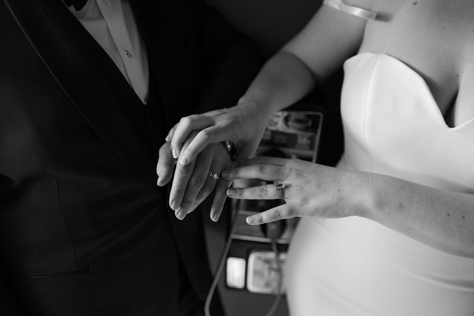 Black and white photo of a bride and groom holding hands