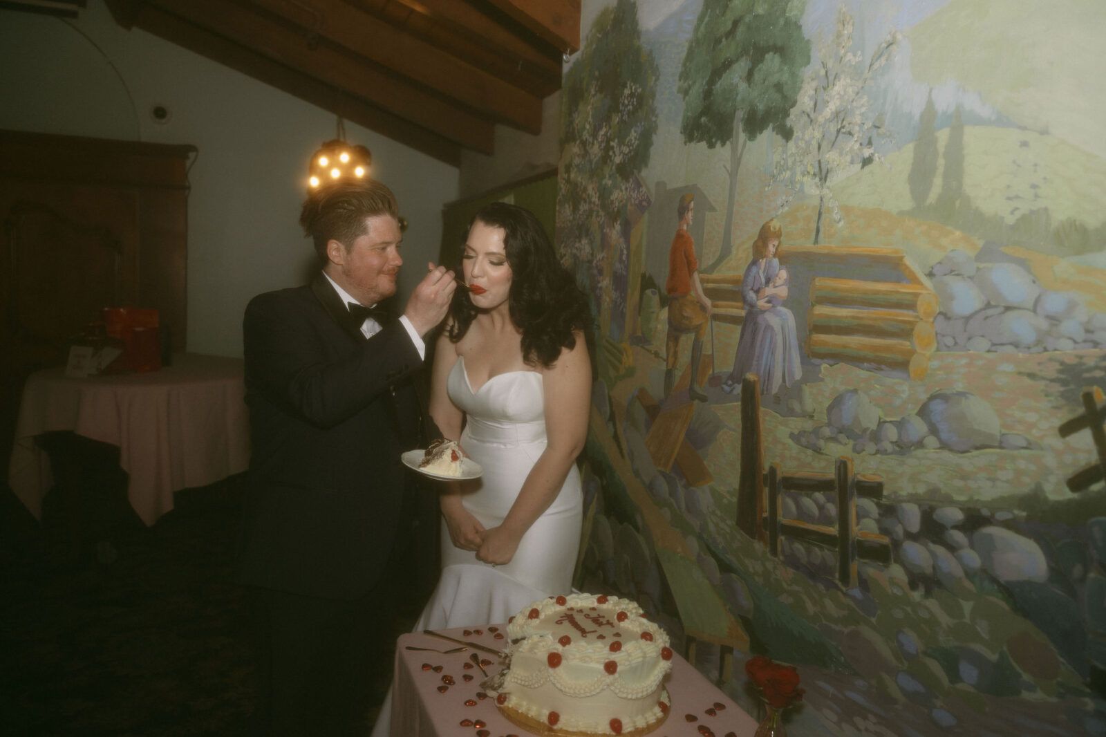 Groom feeding his bride a bite from their wedding cake