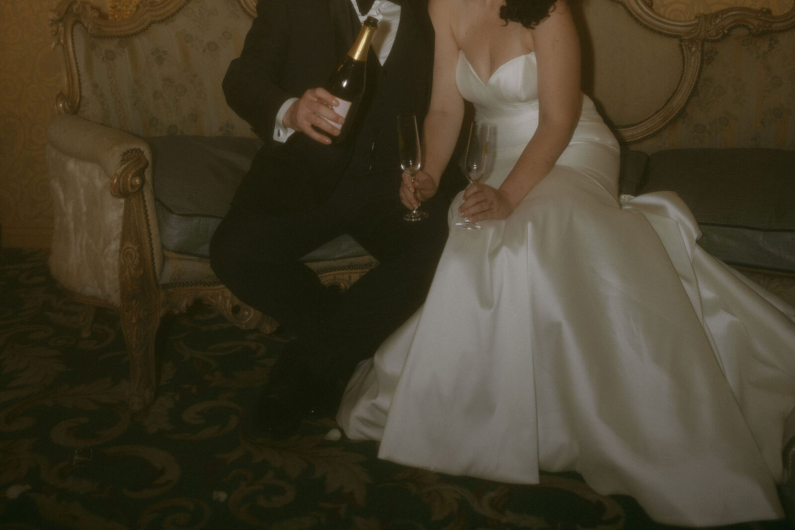 Groom pouring champagne for him and his bride