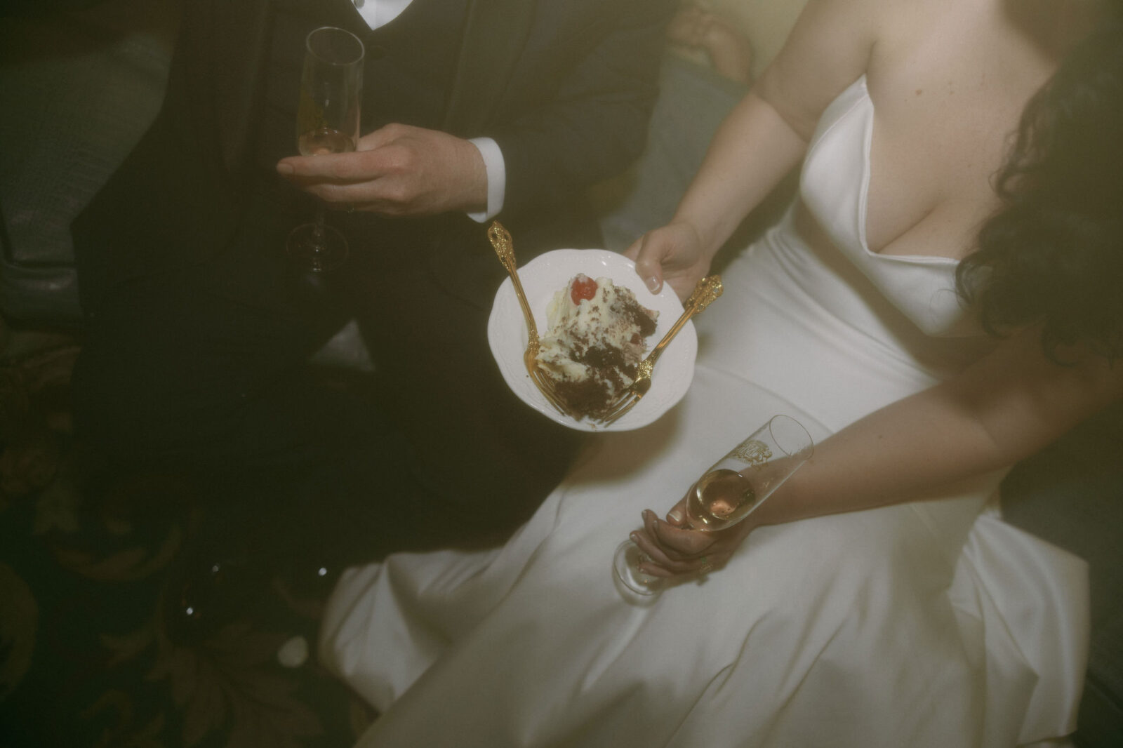 Bride and groom sharing their wedding cake and champagne