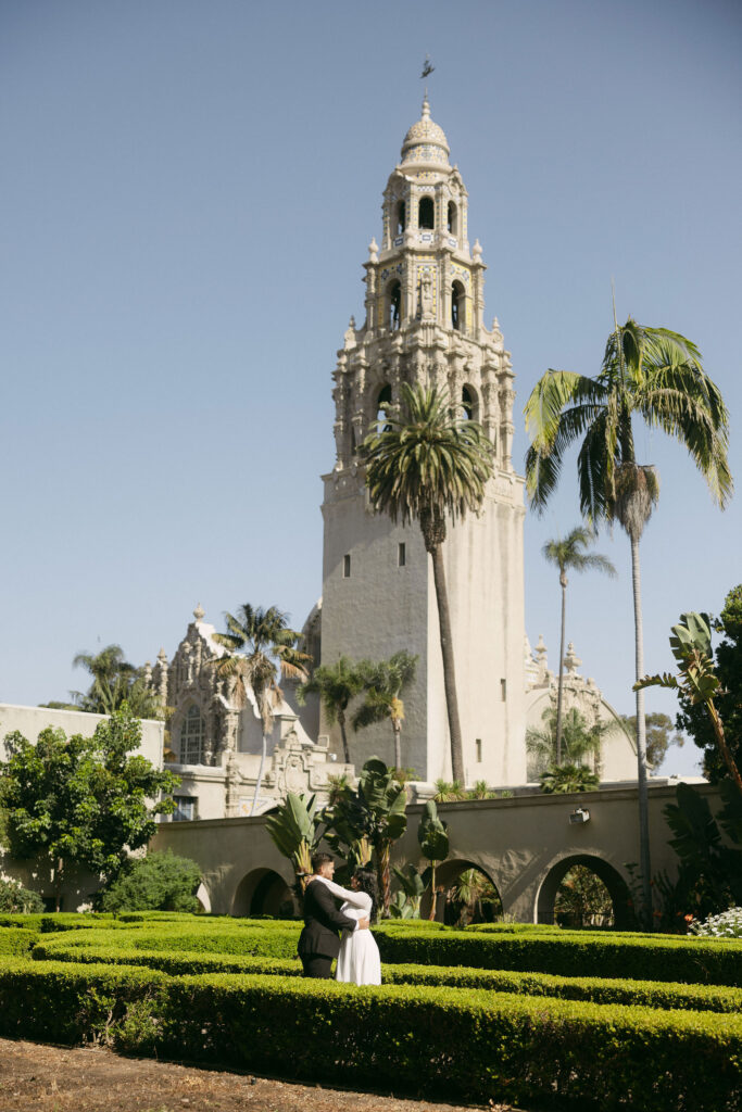 Couple posing in Alcázar Garden for their Balboa Park engagement photos