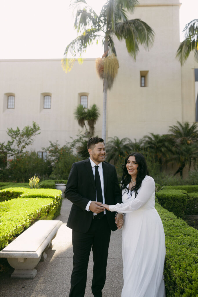 Couple strolling through Alcázar Garden for their Balboa Park engagement photos in California