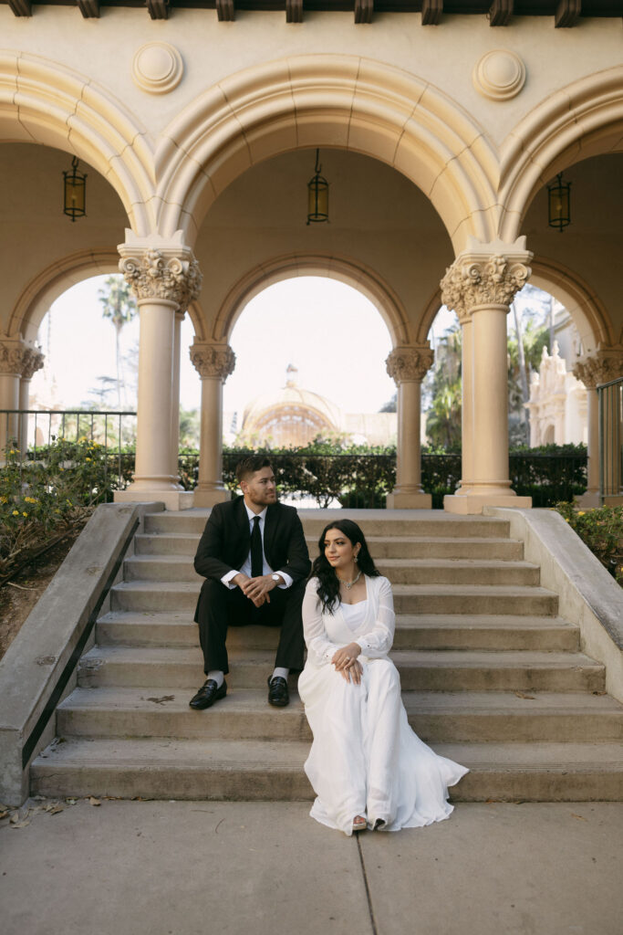 Man and woman posing on stairs in Balboa Park