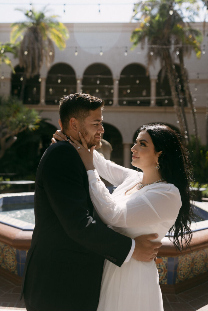 Man and woman posing for their Balboa Park engagement photos