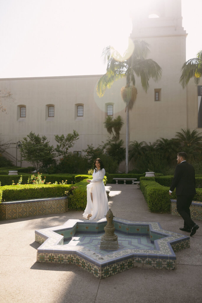 Couple strolling through Alcázar Garden for their Balboa Park engagement photos in California