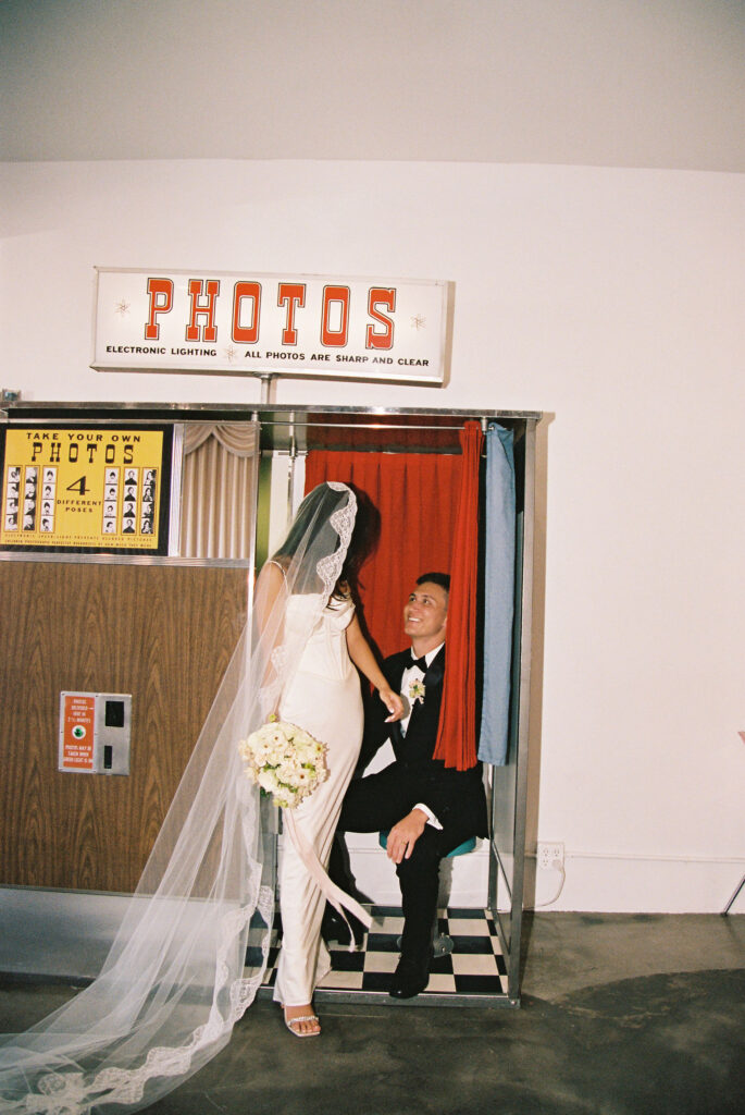 Film photo of a bride and groom posing in Sure Thing Chapels vintage photo booth