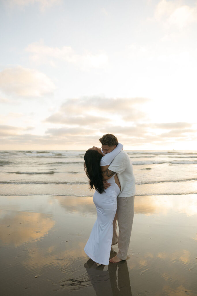 Man hugging his wife during their San Diego maternity photos