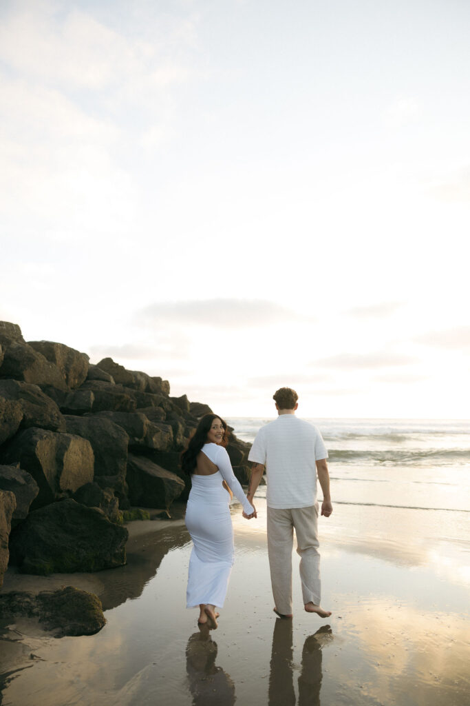 Man and woman walking along the beach in San Diego