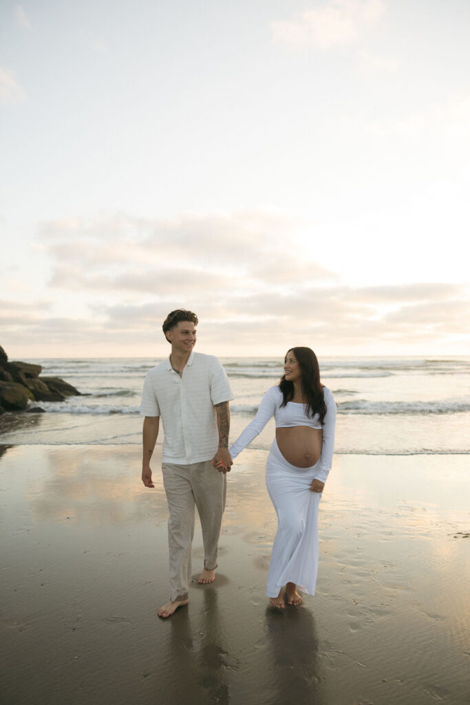 Man and woman holding hands and walking on the beach