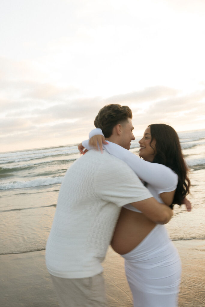 Man hugging his pregnant wife during their San Diego maternity photos