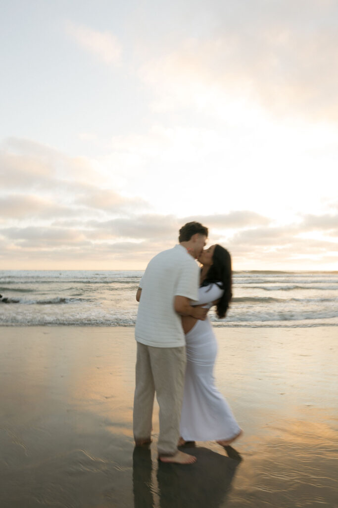 Man and woman kissing on the beach in San Diego