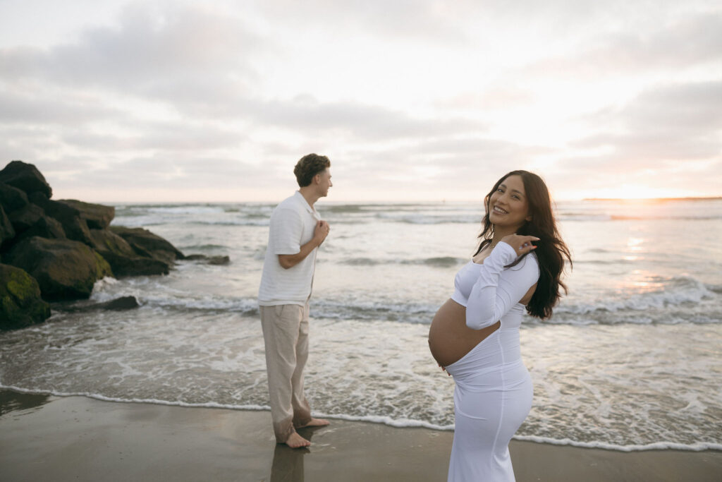 Man and woman posing for their San Diego maternity photos during sunset