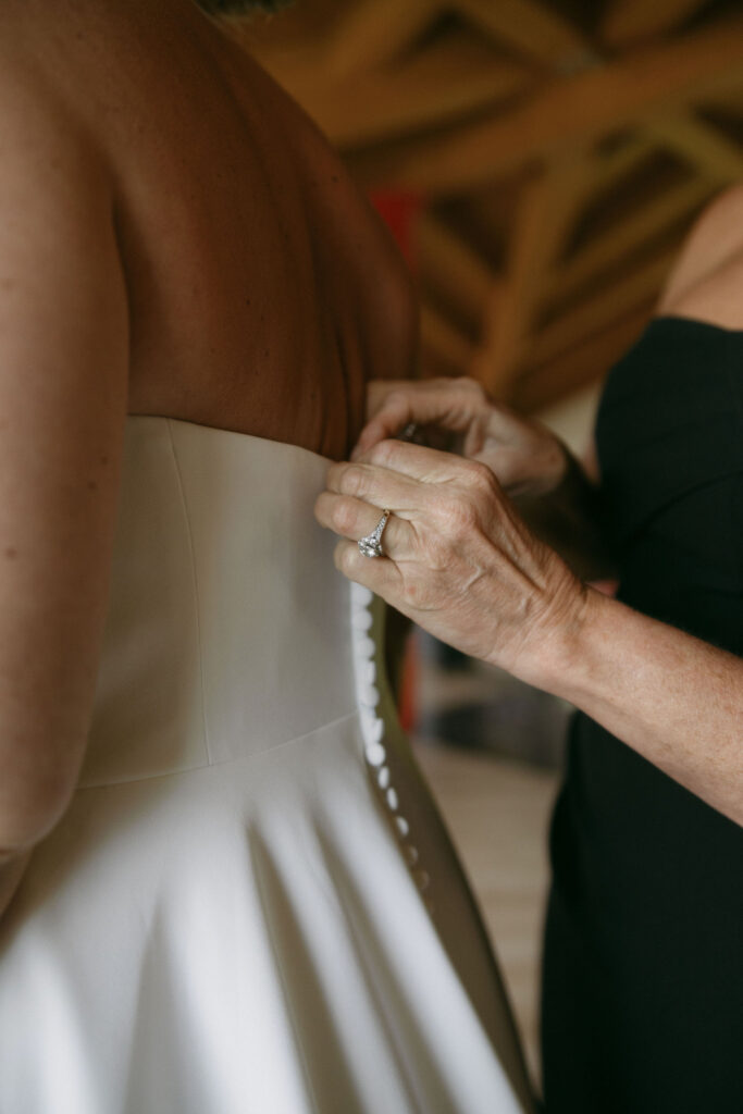 Bride getting her wedding dress buttoned up