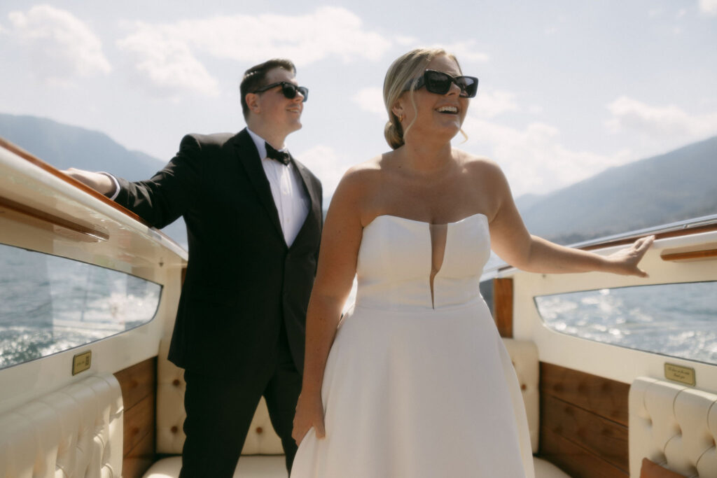 Bride and groom admiring the views of Lake Como, Italy while on a boat