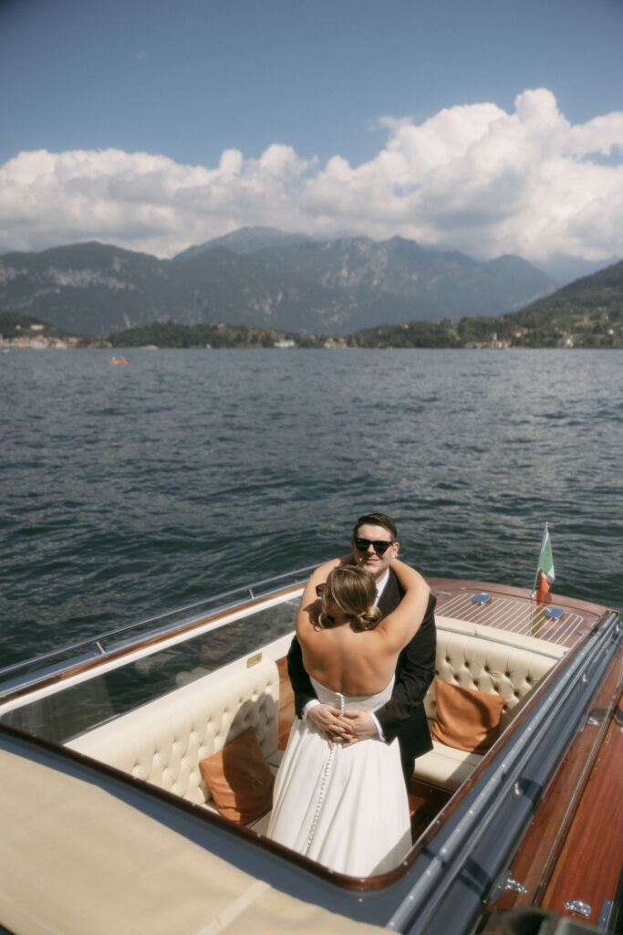 Bride and groom holding each other on a boat on Lake Como