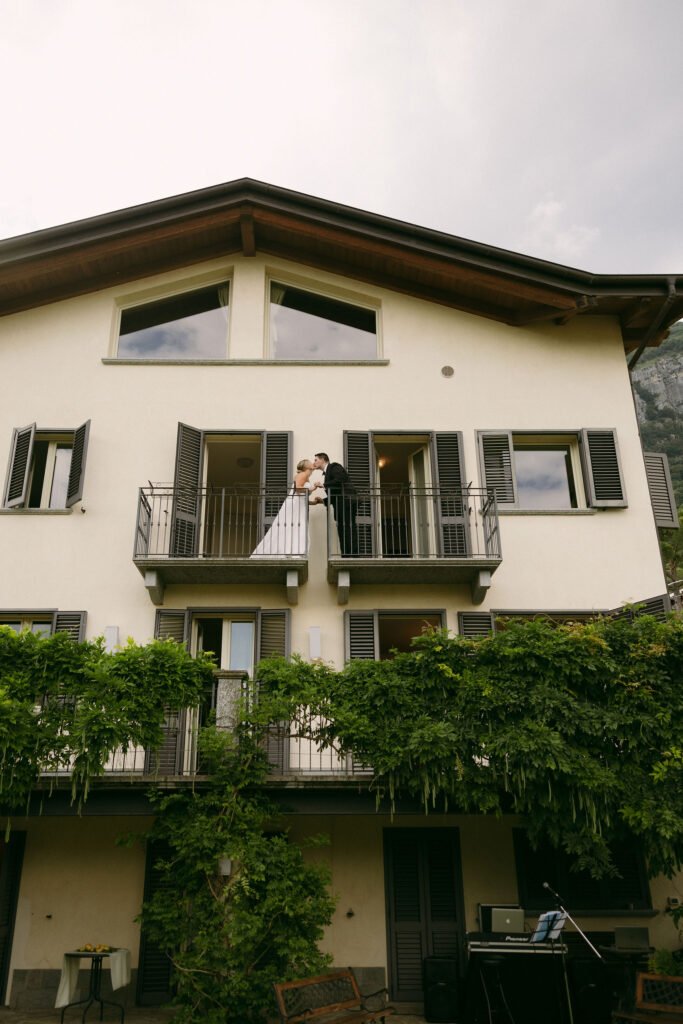 Bride and groom posing on their Lake Como Airbnb balcony