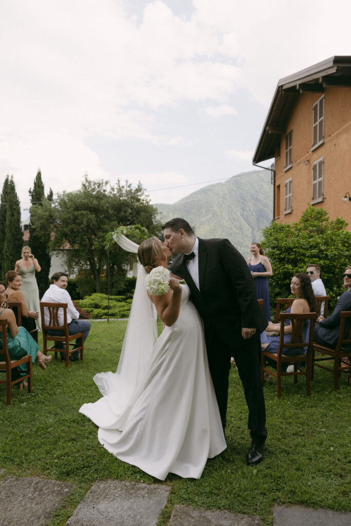 Bride and groom kissing at the end of the aisle after their ceremony