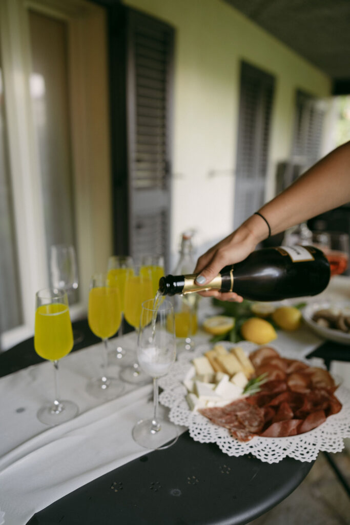 Guest pouring sparkling wine into glasses