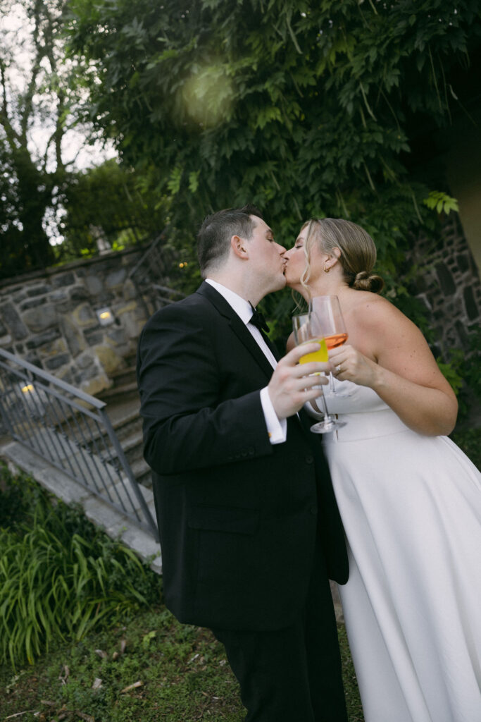 Bride and groom kissing during their cocktail hour