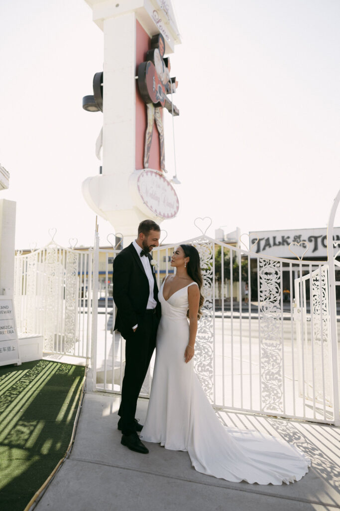 Bride and groom posing outside of The Little White Chapel for their elopement photos