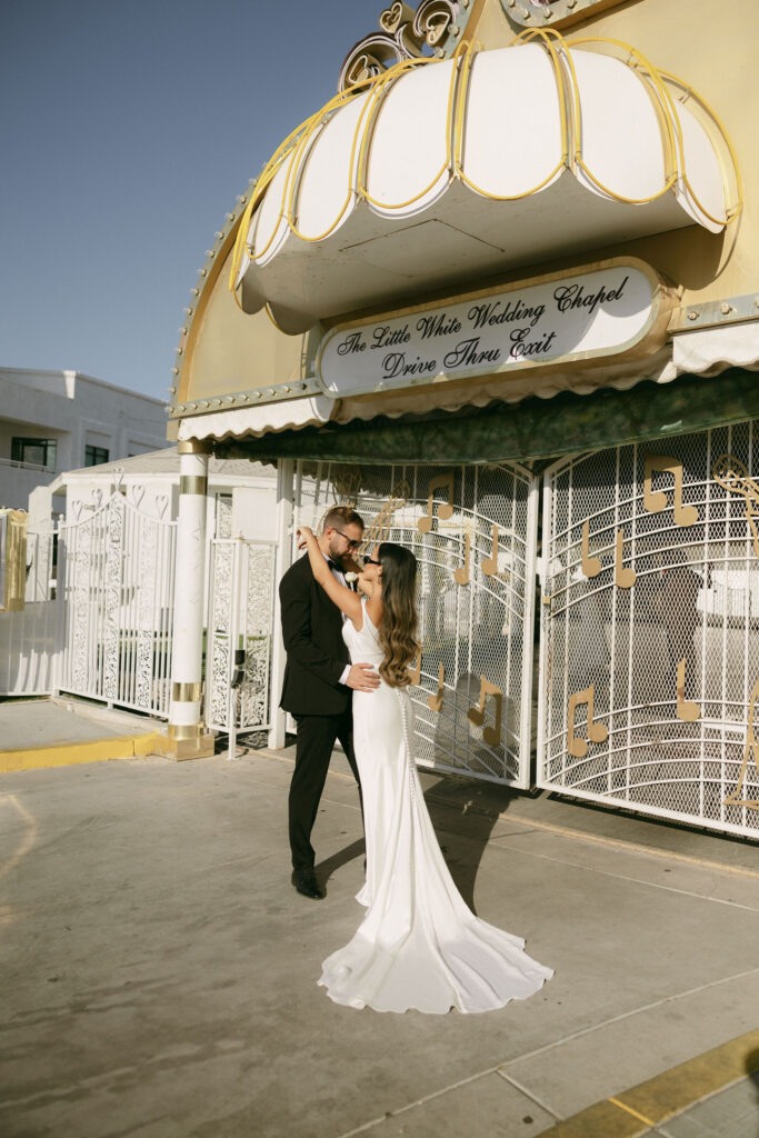 Bride and groom posing outside of the Drive-Thru exit at The Little White Chapel in Las Vegas