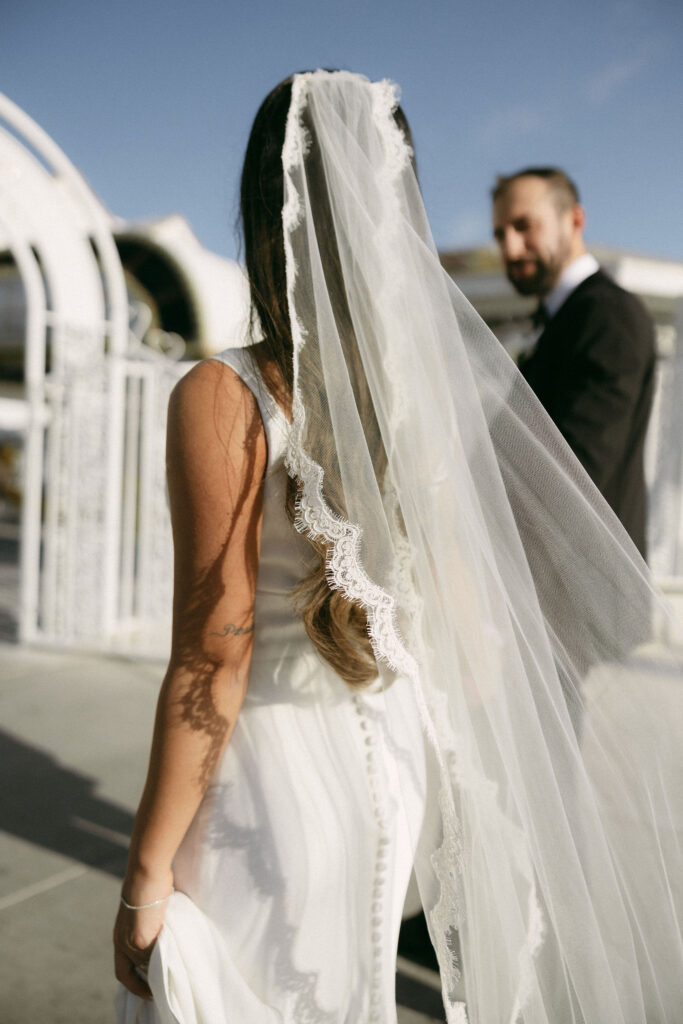 Close up shot of a bride and groom holding hands outside of LWC