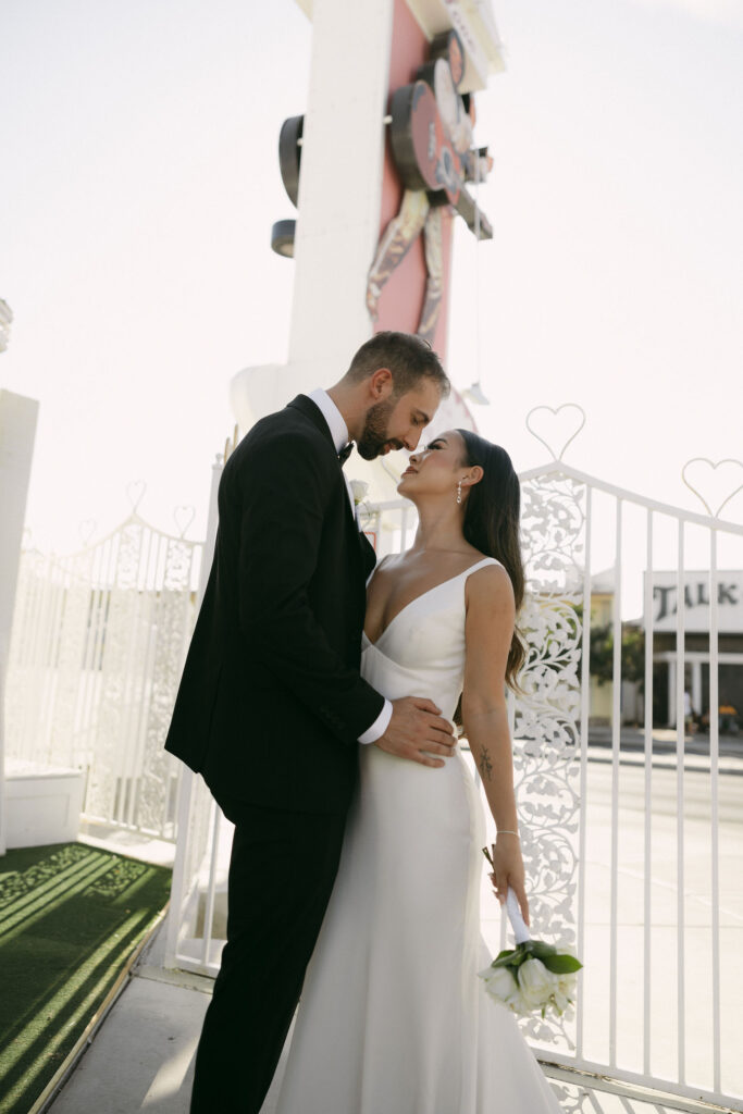 Bride and groom posing outside of The Little White Chapel for their elopement photos