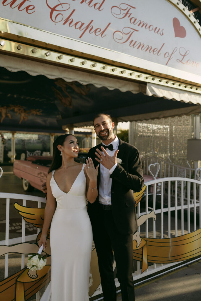 Bride and groom showing off their rings outside of The Tunnel of Love