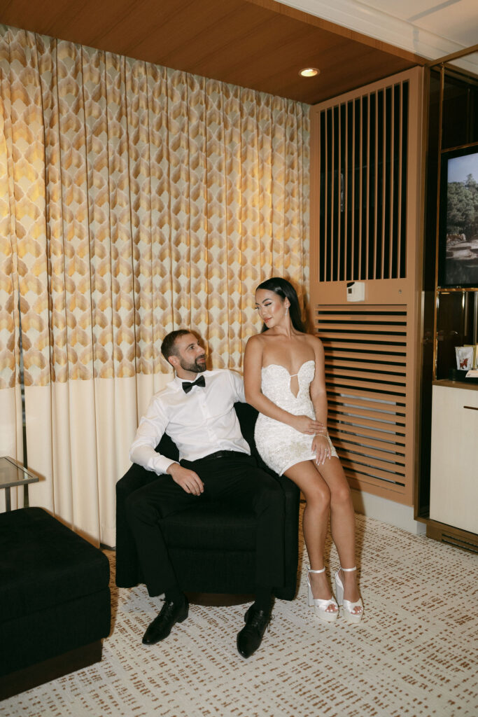 Bride and groom sitting on a chair inside of their Wynn Las Vegas hotel room