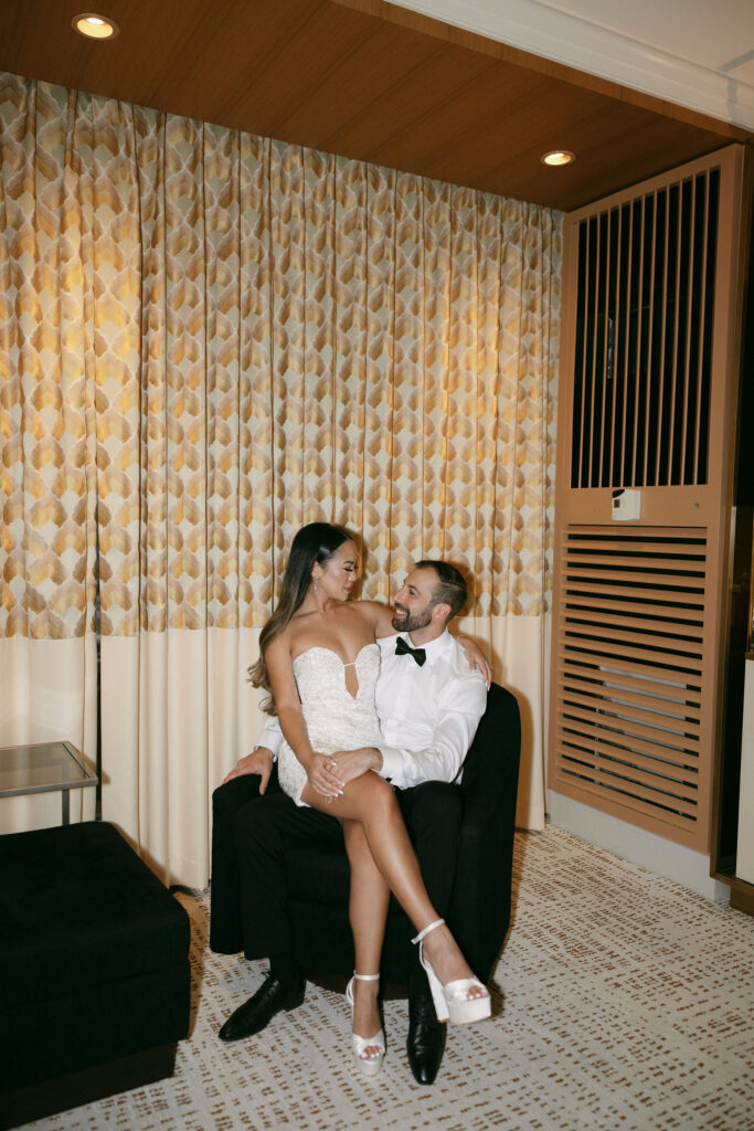 Bride and groom sitting on a chair inside of their Wynn Las Vegas hotel room