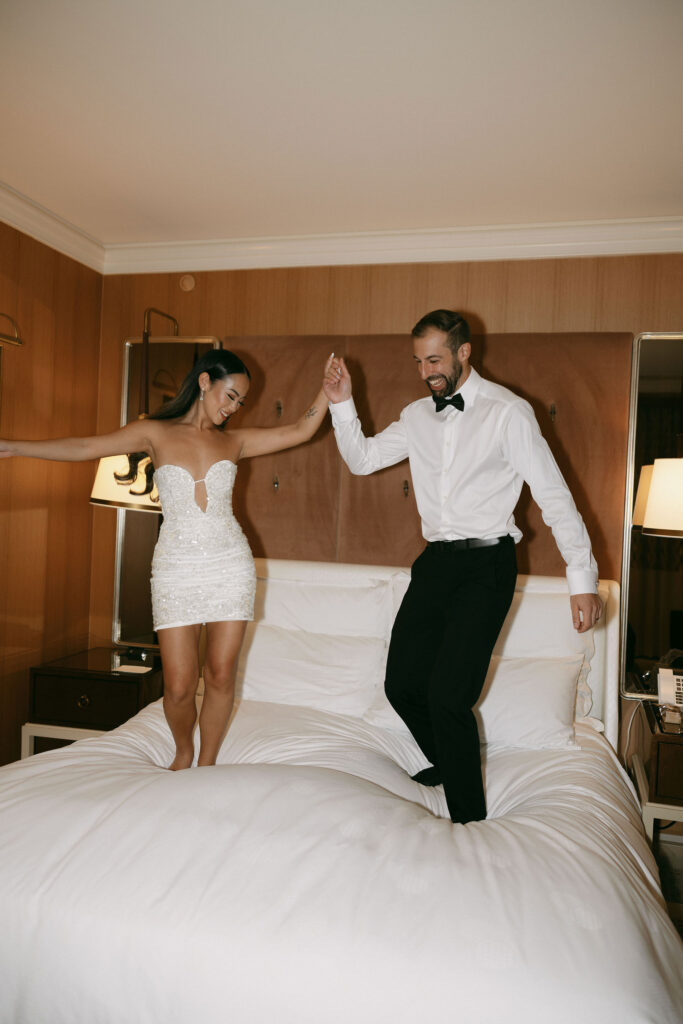 Bride and grooms Wynn Las Vegas elopement photos of then jumping on the bed