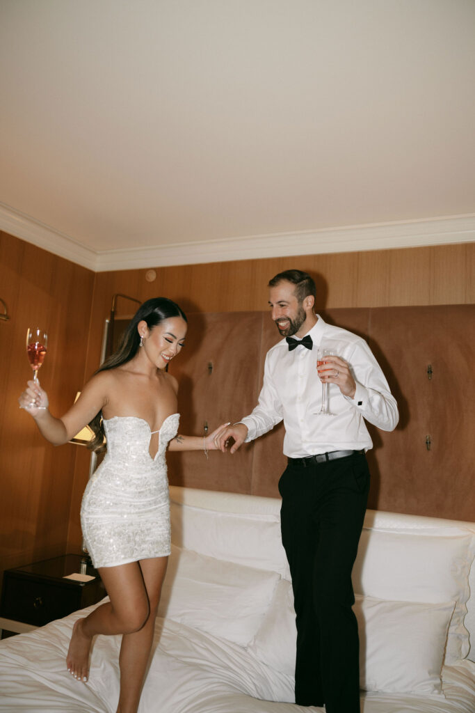 Bride and grooms Wynn Las Vegas elopement photos of then jumping on the bed