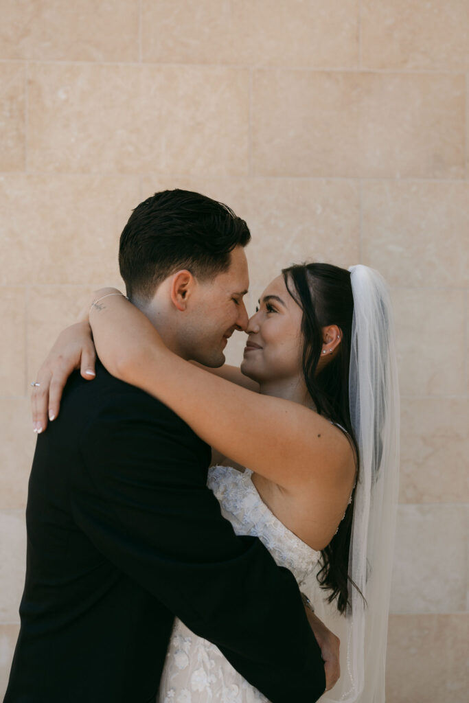 Bride and groom touching noses during portraits