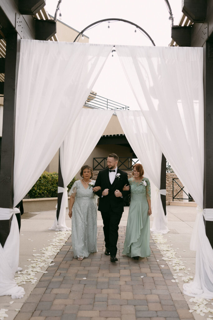 Groom being walked down the aisle