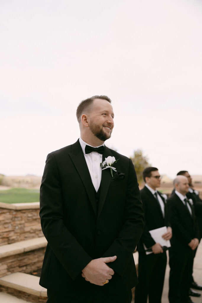 Groom smiling as he sees his bride walking down the aisle